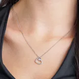 Collar plateado con dije de corazón calado con pequeños brillantes y un brillante colgante.