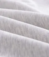 Buzo con capucha y cierre frontal, confeccionado en tejido fleece de algodón y poliéster. Presenta un diseño bicolor con cuerpo en gris melange y paneles laterales en las mangas de color negro, bolsillos frontales, y puños y ruedo en rib.