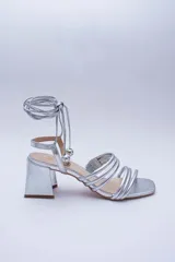 Sandalias doradas con taco cuadrado y tiras finas que se atan al tobillo. Capellada, forro y plantilla 100% de cuero.