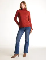 Polera de tejido fino, color rosado, con cuello alto, manga larga y detalle de tajo en los puños.