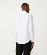 Camisa blanca de algodón, corte slim fit, manga larga y cuello clásico.