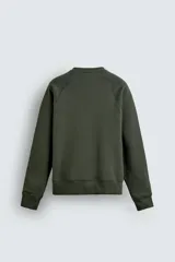 Sudadera de corte relajado confeccionada en algodón compacto con interior de rizo. Presenta cuello redondo, mangas largas tipo raglán y terminaciones en rib.