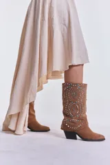 Vestido midi color beige de breteles finos, corte asimétrico y falda con volados.