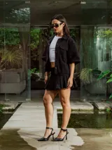 Pollera corta negra de gabardina, estilo plisado, con tiro medio y bordado frontal.