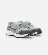 Championes de estilo híbrido entre jogging y Mary Jane, confeccionados en poliuretano. Presentan un diseño con cierre de tira adherente en el empeine, suela robusta y detalles en tonos grises y plateados.