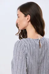 Blusa clásica de manga larga en color blanco, con cuello redondo y diseño fluido.