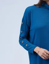 Polera negra de tejido soft con cuello alto y mangas largas con aplique de botones.