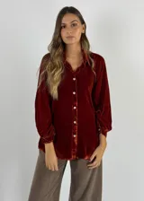 Camisa verde oscuro de terciopelo de viscosa, con cuello mao, corte recto, mangas largas abullonadas y cierre frontal con botones.