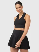 Top deportivo tipo polo de corte cropped, con cuello clásico y escote en V. Presenta un diseño ajustado al cuerpo y espalda estilo nadadora.