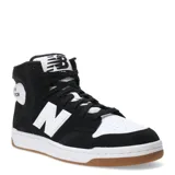 Championes de caña media New Balance modelo 480, con diseño inspirado en el básquetbol. Presentan una combinación de colores negro y blanco, con el logo 'N' característico en los laterales, puntera perforada y suela de goma color caramelo.