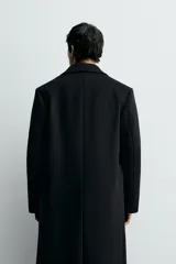 Abrigo de corte relajado confeccionado en tejido con lana y cashmere. Presenta cuello con solapas de muesca, manga larga, bolsillos con solapa en la cadera y cierre frontal de botonadura cruzada.