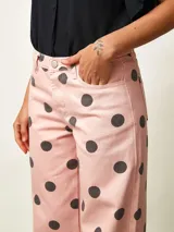 Pantalon tipo jean de corte recto, color rosado con estampa de lunares negros.