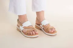 Sandalias de cuero color tostado con tiras cruzadas y detalle de tira ancha blanca en el empeine.