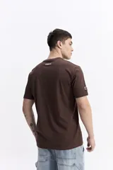 Remera de manga corta color marrón, con escote redondo y estampado frontal con la frase "Never Give Up" y el logo de la marca Mistral.