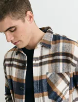 Sobrecamisa de manga larga con diseño a cuadros, cuello camisero y bolsillo frontal. Confeccionada en tejido de poliéster y algodón, sin forro.