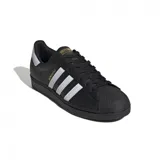 Championes Adidas Superstar negros con las tres tiras blancas y detalles dorados.