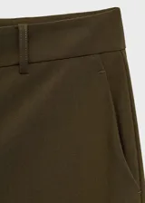 Pantalon de corte recto y tiro medio, confeccionado en tejido ligero con forro interior. Presenta cierre frontal con cremallera, botón y ganchos ocultos bajo tapeta, además de trabillas para cinturón y dos bolsillos laterales.