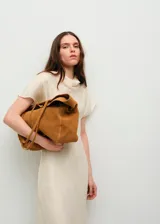 Bolso tipo shopper de gran tamaño confeccionado en cuero vacuno color tostado, con diseño de solapa y correas largas para llevar al hombro.