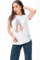 Remera blanca con estampado de zapatos con moños y vestido celeste.