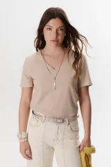 Remera lisa de color beige, con escote en V y mangas cortas de corte clásico.