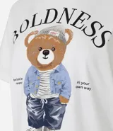Remera de algodón color crudo, de corte recto y manga corta, con cuello redondo y estampa bordada de un oso vestido con chaqueta de jean, gorro y pantalón.