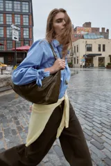 Camisa corta de manga larga, color celeste con finas rayas blancas verticales. Posee cuello solapa y puños anchos ajustados con lazos del mismo tejido.