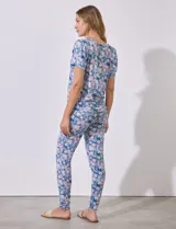 Conjunto de pijama marca Jesica Simpson, confeccionado en tejido soft con estampado floral en tonos azul y rosa. Incluye remera de manga corta con escote redondo y pantalón largo con cintura elastizada y lazo de ajuste.