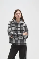 Sweater de tejido jacquard con diseño de cuadros, cuello solapa y cierre frontal parcial. Presenta un corte holgado y mangas largas.