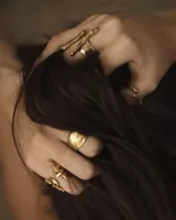 Anillo de diseño abierto con estructura de rejilla entrelazada, elaborado artesanalmente en metal con acabado plateado.