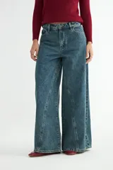 Jean de corte wide leg con diseño de costuras verticales decorativas en el frente, tiro medio y cierre frontal con botón y cremallera.