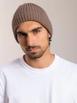 Gorro de lana marrón con diseño de punto canalé y etiqueta de cuero con logo en el lateral.