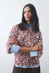 Sweater de punto con diseño de estampado animal print abstracto en tonos tierra y azul claro. Presenta cuello redondo a la base, mangas largas levemente amplias y terminaciones acanaladas en puños y ruedo.