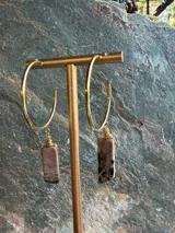 Aros de aro grande dorado con dijes colgantes rectangulares de piedra rodocrosita con detalles envueltos en alambre dorado.