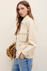 Campera estilo militar color beige, con cierre frontal y bolsillos aplicados en el pecho.