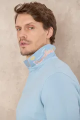 Chomba azul de piqué de algodón con cuello polo, tapeta de dos botones con diseño estampado en el interior y mangas cortas. Corte clásico.