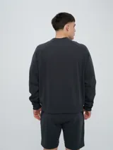 Buzo de felpa bordó, estilo relaxed, con cuello redondo y mangas raglán. Presenta puños y dobladillo acanalados, y una pequeña etiqueta con el logo de Umbro en el lateral inferior.
