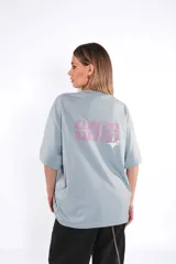 Remera oversize de algodón celeste con estampado frontal en color rosado.