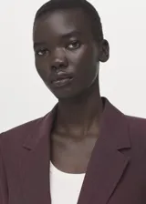 Blazer de diseño recto estilo traje, color bordó, confeccionado en tejido de lyocell. Cuenta con cuello pico con solapa de muesca, manga larga con puños abotonados, dos bolsillos laterales con solapa y cierre frontal de un botón.