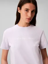 Remera de algodón regenerativo color lila, de corte clásico y manga corta, con cuello redondo y el logo de Calvin Klein Jeans estampado en el pecho.