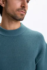 Buzo de punto con cuello redondo y diseño acanalado, de manga larga y corte holgado.