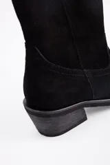 Bota de caña media estilo western, confeccionada en cuero vacuno con acabado de gamuza en color marrón, con taco cuadrado y puntera redondeada.