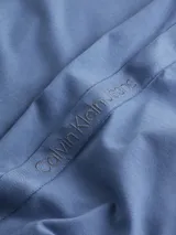 Remera celeste de algodón con cuello redondo y mangas cortas. Cinta con logo Calvin Klein en espiguilla en los laterales.