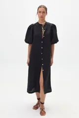 Vestido midi negro confeccionado en lino, con cuello mao, mangas abullonadas hasta el codo y cierre frontal con botones de nácar.