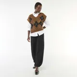 Pantalón de punto color negro, con diseño amplio y textura arrugada, corte holgado y puños ajustados en los tobillos.