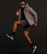 Campera puffer deportiva Get Over, color negro, con capucha, cierre frontal por cremallera y puños elásticos. Diseño acolchado sin costuras visibles.