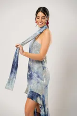 Vestido corto con estampado abstracto en tonos azules y beige. Presenta escote halter con pañuelo al cuello, corte irregular y ruedo con volados.