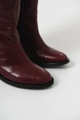 Bota de caña alta color bordó, 100% cuero, con cierre lateral y taco cuadrado forrado.