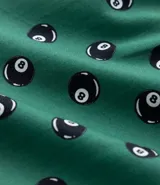 Calzoncillo tipo bóxer de tela tricolina color verde, con estampado de bolas ocho de billar en negro y blanco. Tiene cintura elástica y botones frontales.