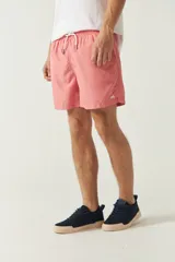 Short de baño liso para hombre, con cintura elástica y cordón ajustable. Cuenta con dos bolsillos laterales, un bolsillo trasero y logo bordado en la parte inferior.