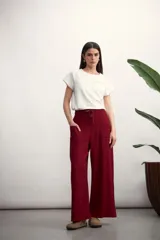 Pantalón de corte ancho y tiro alto, confeccionado en tejido de textura natural. Presenta cintura elástica con cordón ajustable, bolsillos laterales tipo parche y diseño de pierna recta y holgada.